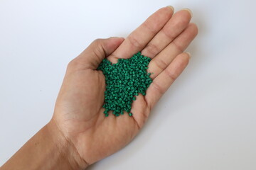 Primary color mix. Green plastic pellets, rubber granules on a white background