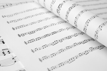 Sheets of paper with music notes as background, closeup