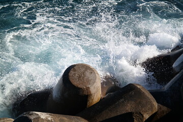 Waves break against the breakwater - obrazy, fototapety, plakaty