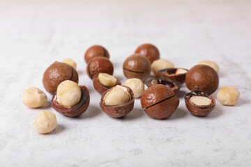 Delicious organic Macadamia nuts on white textured table, closeup