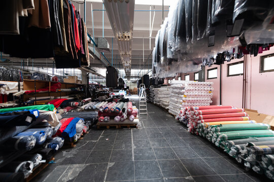 Interior of an industrial warehouse with fabric rolls samples. Small business textile colorful warehouse.