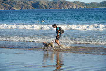 Hombre joven jugando con su perro en el mar