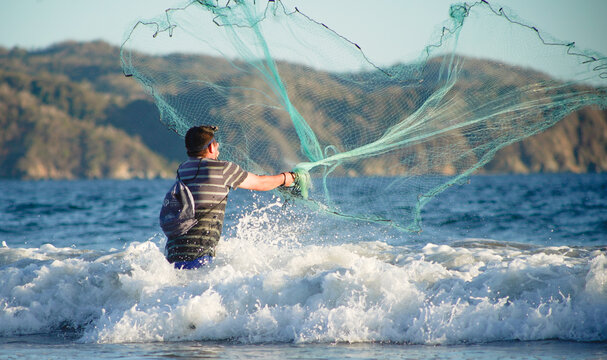 Pescador lanzando red en el mar