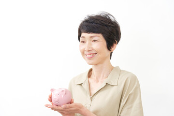 笑顔で貯金箱を持つ中年女性　白背景