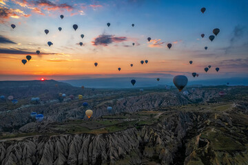 Sunrise panorama of famous Cappadocia landscape view with lots of hot air balloons flying - 589368003