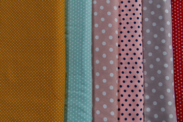 Collection of fashionable fabrics. Samples of different natural fabrics for sewing a fashion collection of clothes. Large selection of fabrics in the store or tailor warehouse.