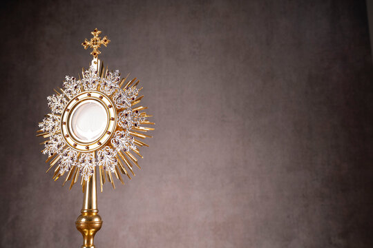 Catholic religion concept. Easter.The monstrance and golden chalice on gray background. 
