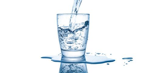 Pouring water into a clear glass and isolated on white background