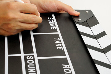 Focus the hand is holding clapperboard or movie slate black color and marker pen. Cinema industry...