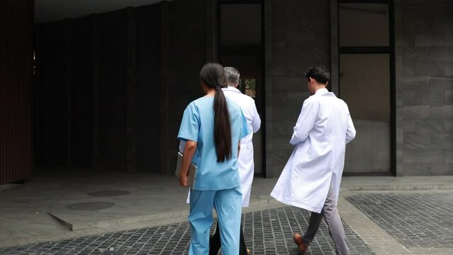Back view Professional medical staff people successful and teamwork concept. Diverse doctor and nurse walking and talking together at hospital medical wellness center