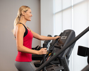 Fototapeta na wymiar Blonde woman running on the treadmill