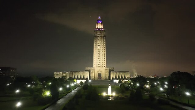 Louisiana state capitol building in Baton Rouge, Louisiana at night with drone video moving up.