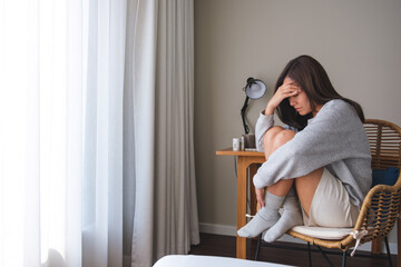 A young woman feeling sad and stressed, sick and headache at home