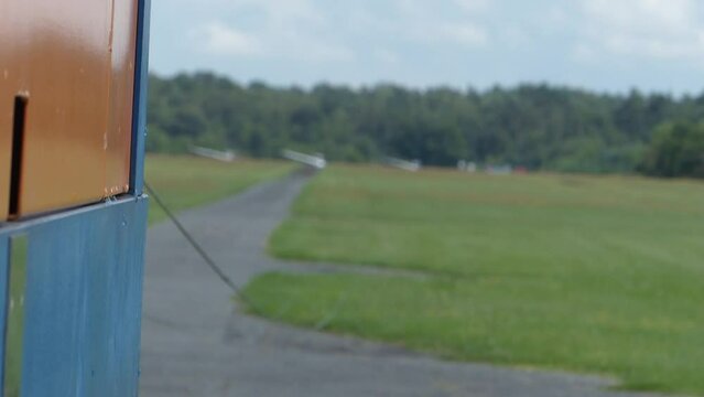 Winch for gliders stands on a way and in the distance there are gliders on the runway