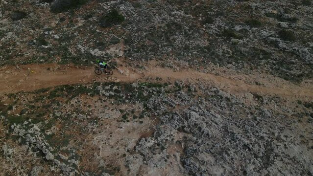 Mountain bike rider tackles hard stretch of rocky ground in bike race.