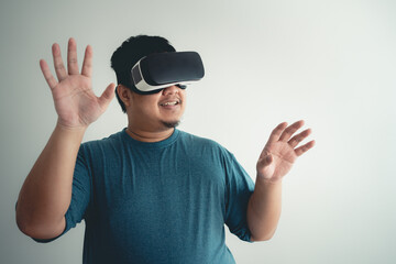 Naklejka premium Asian man enjoy using VR headset for virtual reality access to online data network with laptop.