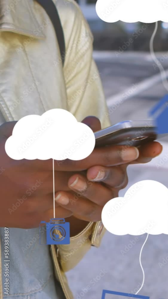 Wall mural Animation of clouds with electronic devices over african american woman using smartphone