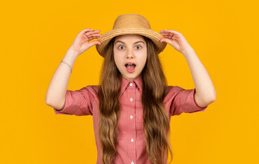 amazed child in straw hat on yellow background