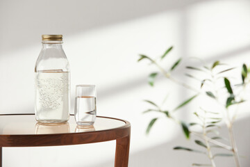 This room has a calm atmosphere with natural light. There are clay pots, glass bottles, coffee and various objects on the table.