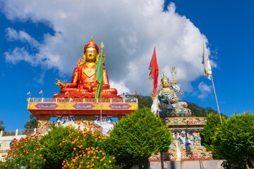 Wide angle view of Holy statue of Guru Padmasambhava or born from a lotus, Guru Rinpoche, Blue sky...