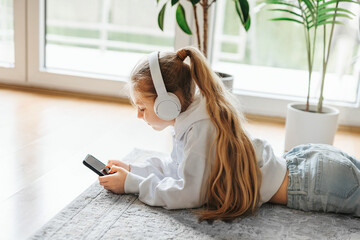 Little girl listening music lying on the floor - Powered by Adobe
