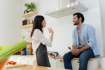 Fototapeta premium Talk to each other during breakfast time. A young couple in love having fun while preparing a breakfast together on a beautiful morning.