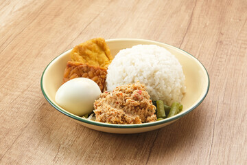 Nasi Gudangan, rice served with various vegetable with grated coconut seasoned and various side dishes. Indonesian food
