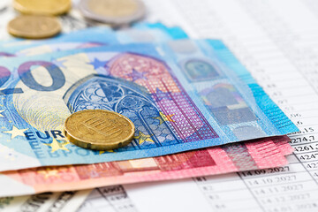 Euro bills and coins on accounting documents.