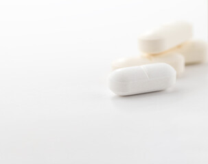 Fototapeta na wymiar Close-up of a white pills or capsules on white table.
