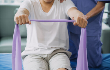 Doctor or Physiotherapist working examining treating injured arm of athlete male patient,...