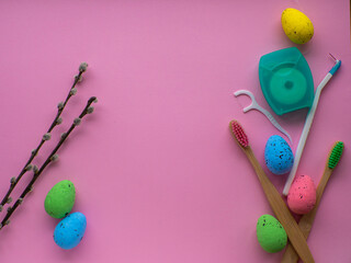 Wooden toothbrushes with Easter decorations on pink background