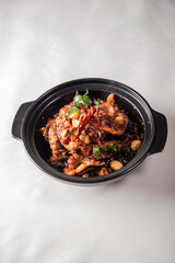local cook live fresh catfish meat with spicy red dry chili asam sauce in big black claypot on wood table asian Chinese banquet halal seafood steamboat menu 