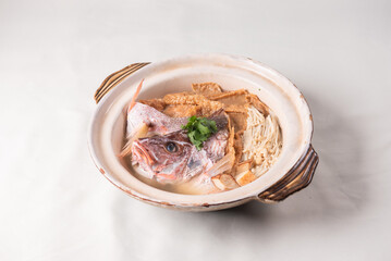 local boiled cook live fresh red grouper fish head with hot herb pepper clear soup in big claypot on wood table asian Chinese banquet halal seafood steamboat menu 