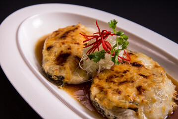 local steam grilled cook live fresh chilean seabass cod fish fillet in Hong Kong style soy sauce on black background asian Chinese banquet halal seafood steamboat menu 