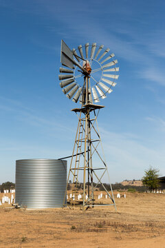 Old Australian Windmill Pumping Water In Desert Landscape