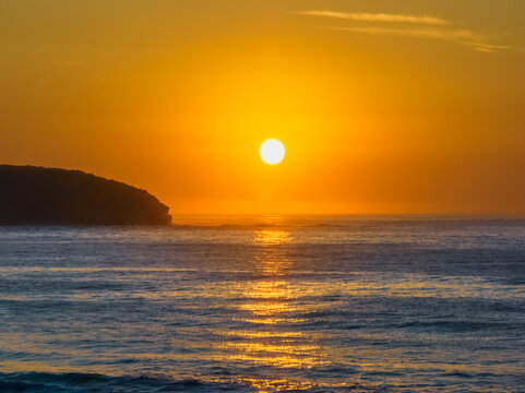 Soft hazy sunrise seascape and orange sky and full sun