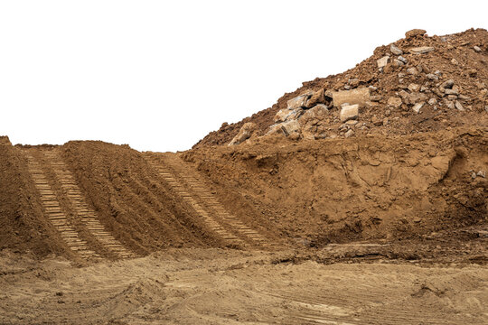 Isolate mounds of sand and concrete debris that have been excavated and poured together with backhoe wheels to prepare materials for filling and repairing roads in rural Thailand during the dry season