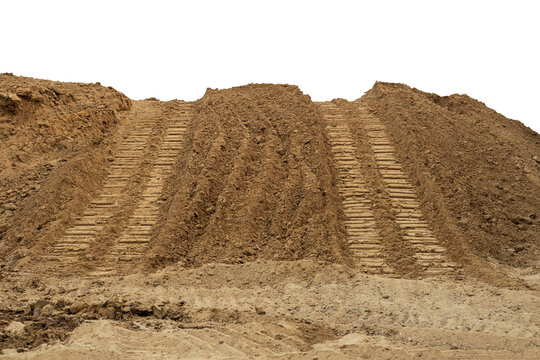 Isolate mounds of sandy brown soil that have been excavated and poured together with large backhoe wheels to prepare materials for filling and repairing roads in rural Thailand during the dry season.