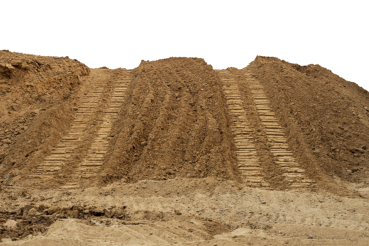 Isolate mounds of sandy brown soil that have been excavated and poured together with large backhoe wheels to prepare materials for filling and repairing roads in rural Thailand during the dry season.