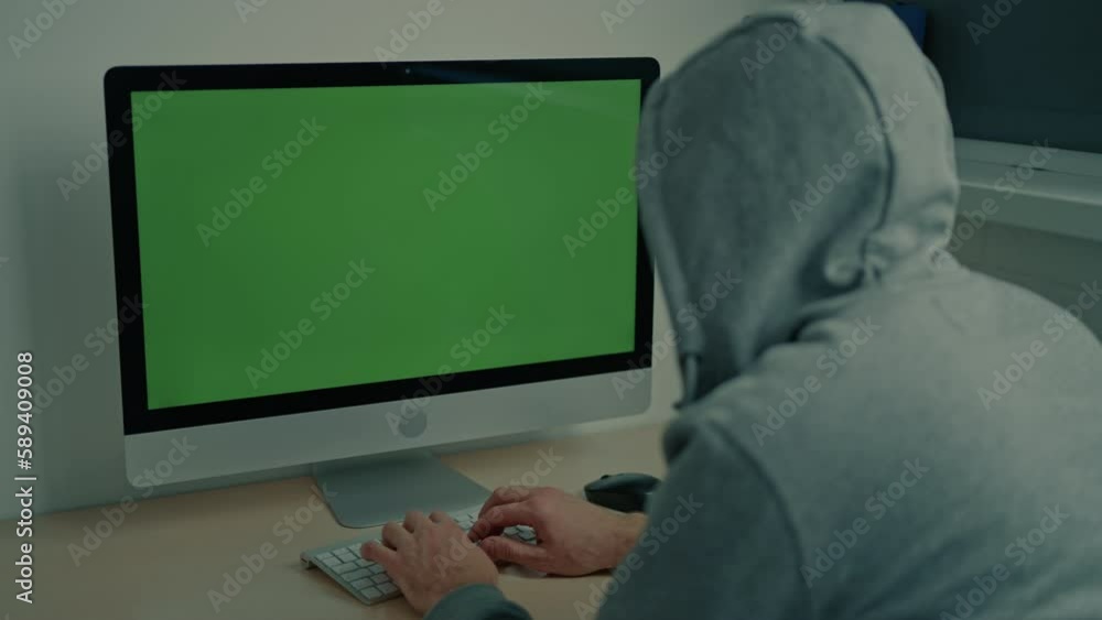 Aufkleber man wearing gray hood typing on keyboard using pc display with green screen minimalist workplace at 