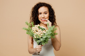 Sad unhappy young woman bride wear wedding dress posing hold flowers look camera biting nails finger isolated on plain pastel light beige background studio portrait Ceremony celebration party concept