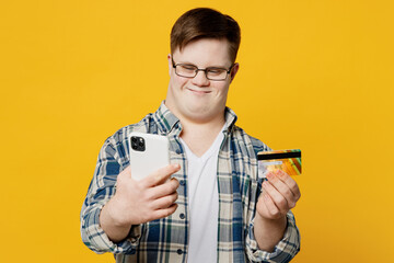 Young man with down syndrome wear casual clothes using mobile cell phone credit bank card shopping...