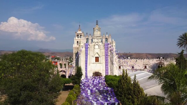 aerial view of old church in mexico in jacaranda season