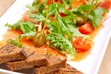 salmon sashimi with salad and tomatoes