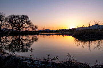 琵琶湖畔にある小さな池の夕暮れ　夕陽に染まる水面