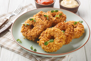 Fried crispy breaded chicken donuts close-up on a plate on the table. Horizontal