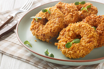 Homemade fried chicken donuts or big nuggets close-up on a plate on the table. Horizontal