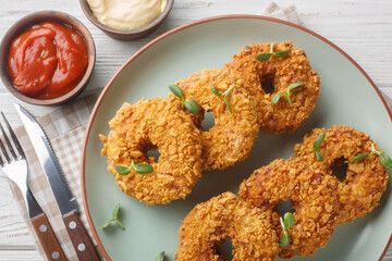 Breaded chicken donuts made from pulled chicken with vegetables and deep fried close-up on a plate on the table. Horizontal top view from above