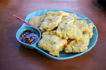 Tempe Mendoan is a traditional food made from tempeh which is smeared with flour dough mixed with sliced ​​green onions and spices, and cooked by frying. served with soy sauce and chili chunks