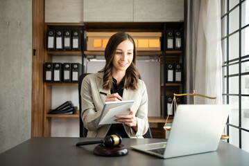 Asian lawyer woman working with a laptop and tablet in a law office. Legal and legal service concept.